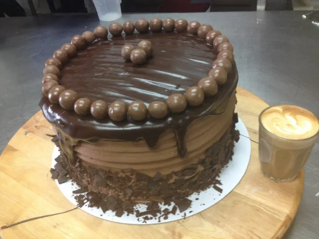 Chocolate ganache cake ringed with malt balls and chocolate shavings
