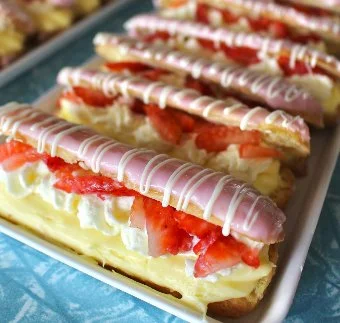 Strawberry eclairs filled with cream and drizzled with pink icing